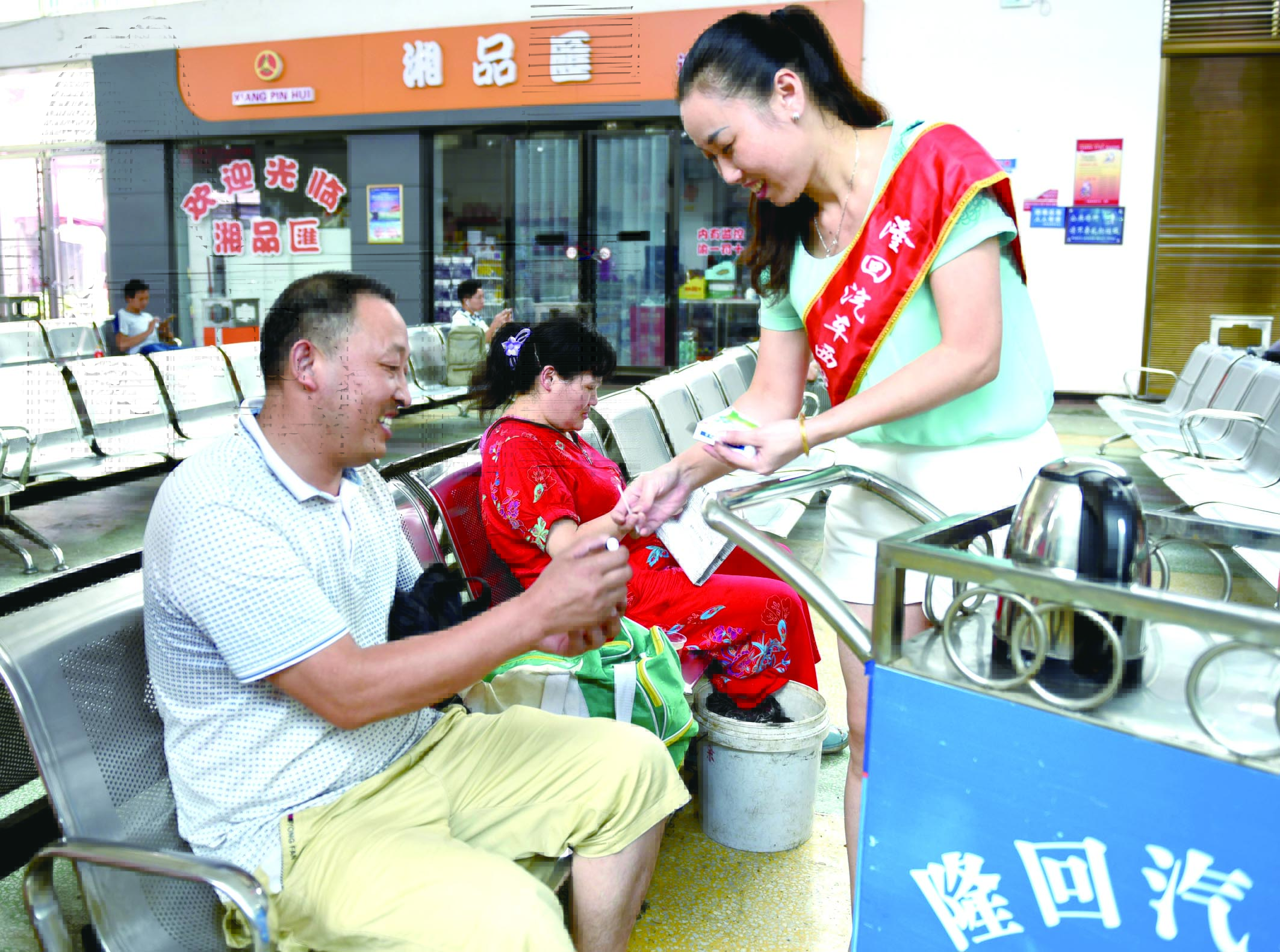 隆回分公司汽車西站工作人員正在為旅客免費(fèi)贈(zèng)送藿香正氣水。